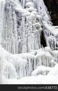 Frozen waterfall with icicles and snow near Bad Harzburg in the fir forests and spruce forests along the main road to Braunlage in the Harz Mountains, winter photo after the onset of spring.