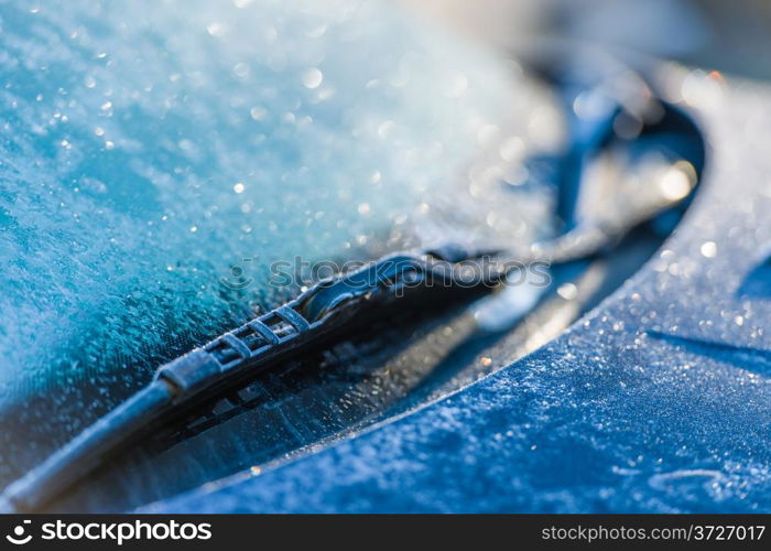 Frozen windshield, cold weather, sunlight on backlight, focus on foreground