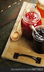 Fruit and berry jam with ingredients on a wooden background