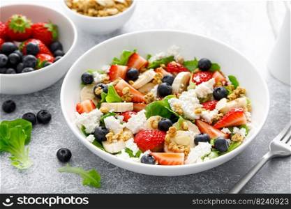 Fruit and berry salad with fresh strawberry, blueberry, banana, cottage cheese and granola with almond. Healthy food, diet breakfast