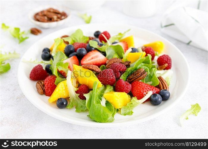 Fruit and berry salad with strawberry, blueberry, raspberry, mango and pecan nuts. Healthy food, diet