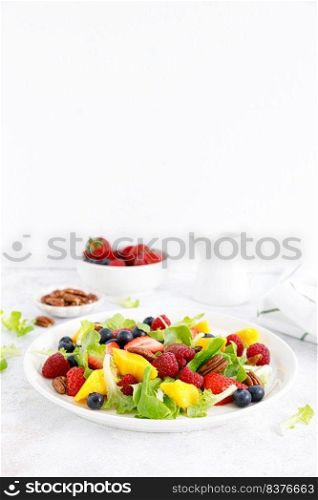 Fruit and berry salad with strawberry, blueberry, raspberry, mango and pecan nuts. Healthy food, diet