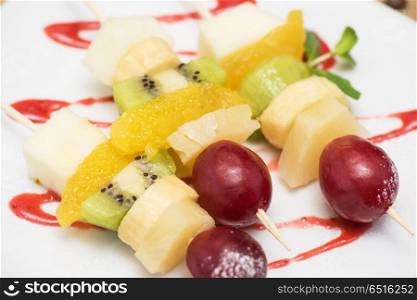 Fruit and cheese plate. Food snack: cheese with grapes, kiwi, orange and banana