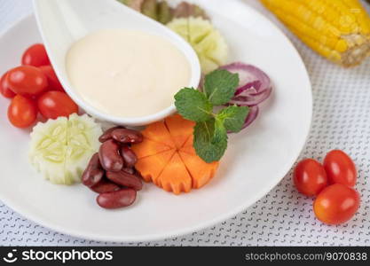 Fruit and vegetable salad on a white plate on a white ground