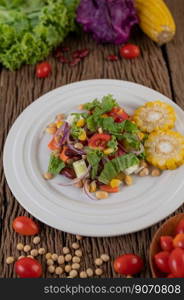 Fruit and vegetable salad on a white plate on a wooden floor