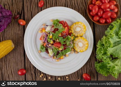 Fruit and vegetable salad on a white plate on a wooden floor