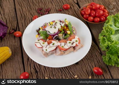 Fruit and vegetable salad on a white plate on a wooden floor