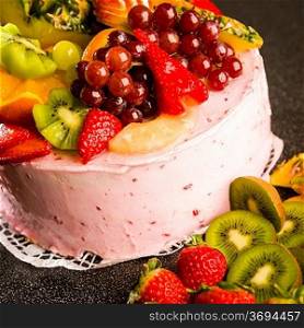 Fruit cake with cream coating and fresh fruits topping