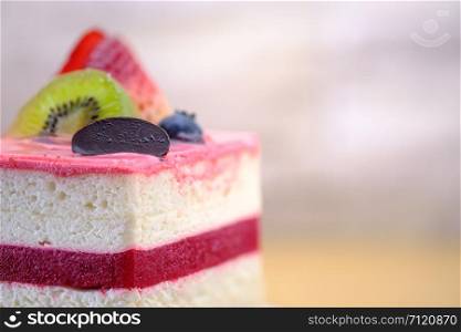Fruit cake with white cream on wooden table, close up, space to write, Select a focus, blurred