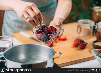 Fruit canning preservation. Woman cooking fruits and making homemade jam.. Woman Cooking Fruits and Making Homemade Jam.