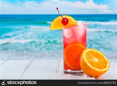 fruit cocktail with orange slice on a beach