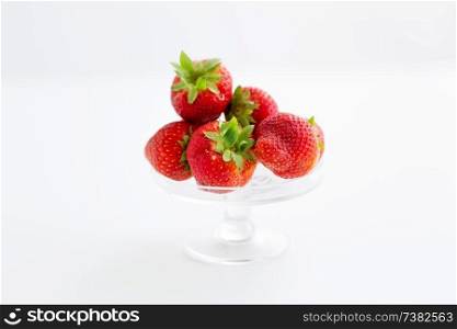 fruit, food and berries concept - strawberries on glass stand over white background. strawberries on glass stand over white background