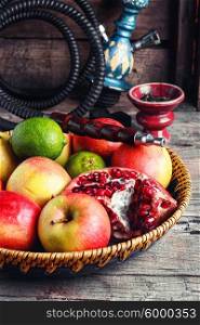 Fruit platter and hookah. Stylish Smoking hookah and basket with apples,pomegranate and lime