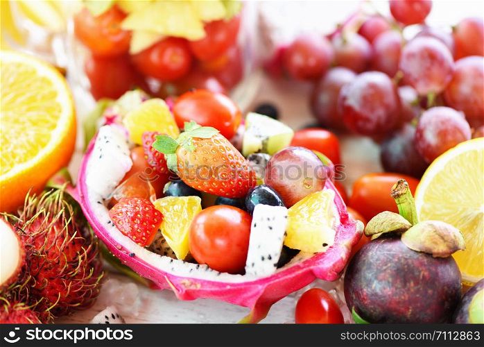 Fruit salad bowl served in a dragon fruit and vegetables healthy organic food strawberries orange kiwi blueberries grape pineapple tomato lemon rambutan fresh summer fruits tropical