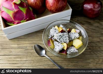 fruit salad in a bowl on the wooden table. Selective focus.