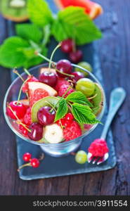 fruit salad in glass bowl and on a table