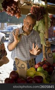 Fruit seller holding money and gesturing, Santo Domingo, Dominican Republic