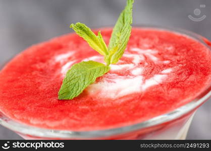 fruit smoothie with a petal in a glass vase on a gray surface.. cocktail with petals