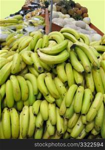 Fruit Stand at grocer with green yellow bananas
