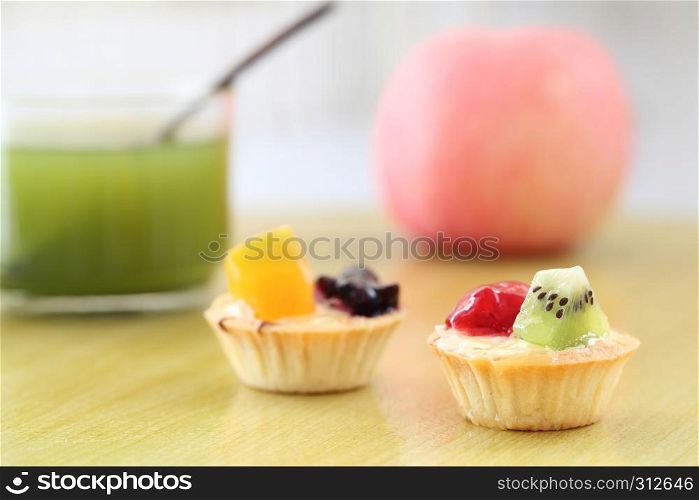 Fruit tart with green tea on wood background