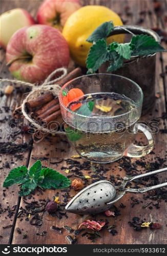 Fruit tea with an apple. Apple tea with cinnamon on a background of custard spoons in the autumn style