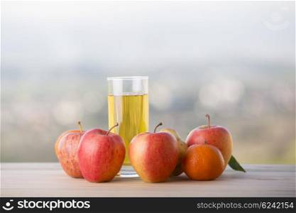 fruits and apple juice on a wooden table, outdoor