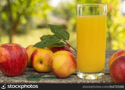 fruits and peach juice on a wooden table, outdoor. fruits and juice