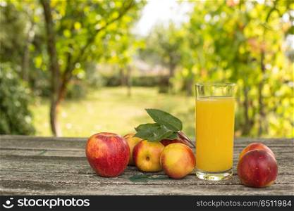 fruits and peach juice on a wooden table, outdoor. fruits and juice