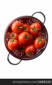 Fruits and vegetables: fresh red tomatoes in a steel colander, overhead view, isolated on white background