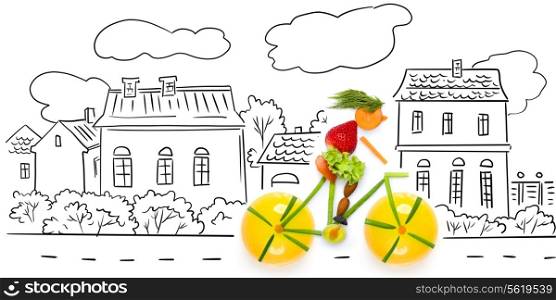 Fruits and vegetables in the shape of a female cyclist riding a bike in the city.
