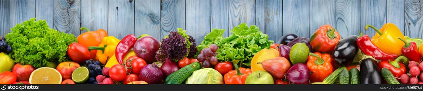 Fruits and vegetables on background of wooden wall. Healthy vegetarian food. Copy space