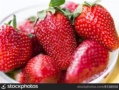fruits, berries, diet, eco food and objects concept - close up of fresh ripe red strawberries over white