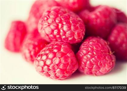 fruits, berries, diet, eco food and objects concept - juicy fresh ripe red raspberries on white