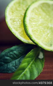 fruits, citrus, detox, diet and objects concept - lime slices on wooden table. lime slices on wooden table