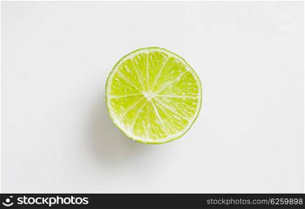 fruits, citrus, diet and objects concept - lime slice over white