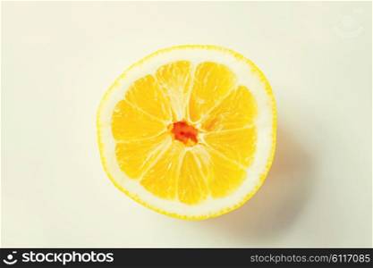 fruits, citrus, diet and objects concept - ripe orange or lemon slice over white