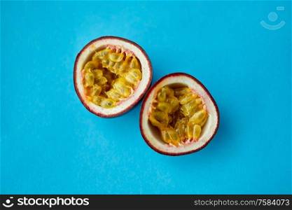 fruits, diet and food concept - close up of cut passion fruit on blue background. cut passion fruit on blue background