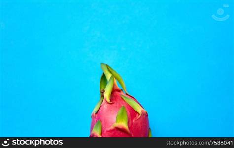 fruits, diet and food concept - close up of ripe dragon fruit or pitaya on blue background. close up of dragon fruit or pitaya on blue