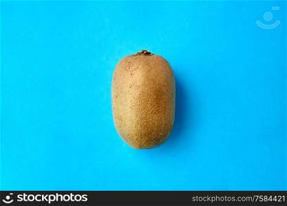 fruits, diet and food concept - close up of ripe kiwi on blue background. close up of ripe kiwi on blue background