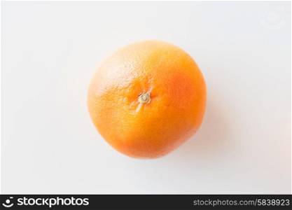 fruits, diet and objects concept - ripe grapefruit over white