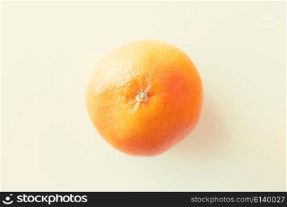 fruits, diet and objects concept - ripe grapefruit over white