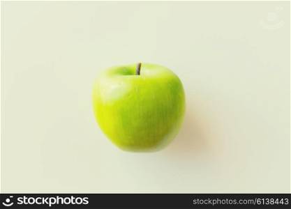 fruits, diet, eco food and objects concept - ripe green apple over white