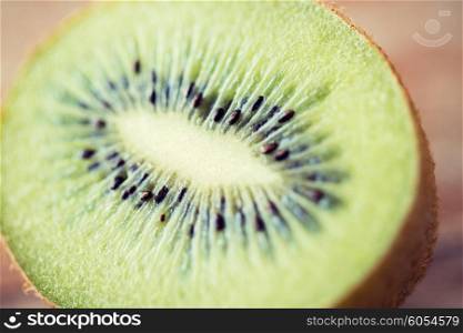 fruits, diet, food and objects concept - close up of ripe kiwi slice on table