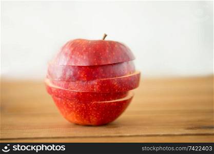fruits, food and harvest concept - sliced red apple on wooden table. sliced red apple on wooden table