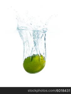 fruits, food and healthy eating concept - close up of fresh lime falling or dipping in water with splash over white background