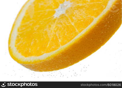 fruits, food and healthy eating concept - close up of slice of fresh orange falling or dipping in water with splash over white background