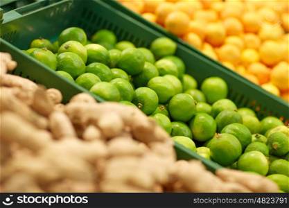 fruits, harvest, food and sale concept - limes at grocery store or market