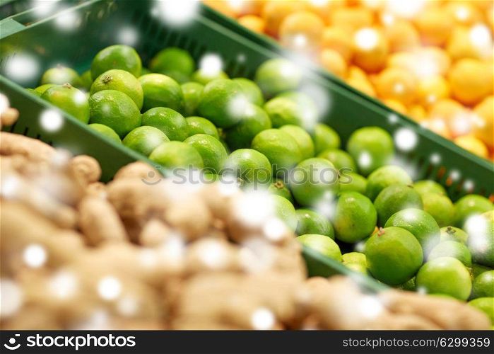 fruits, harvest, food and sale concept - limes at grocery store or market over snow. limes at grocery store or market