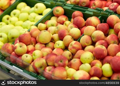 fruits, harvest, food and sale concept - ripe apples at grocery store or market