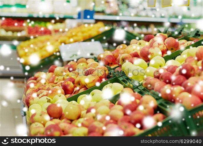fruits, harvest, food and sale concept - ripe apples at grocery store or market over snow. ripe apples at grocery store or market